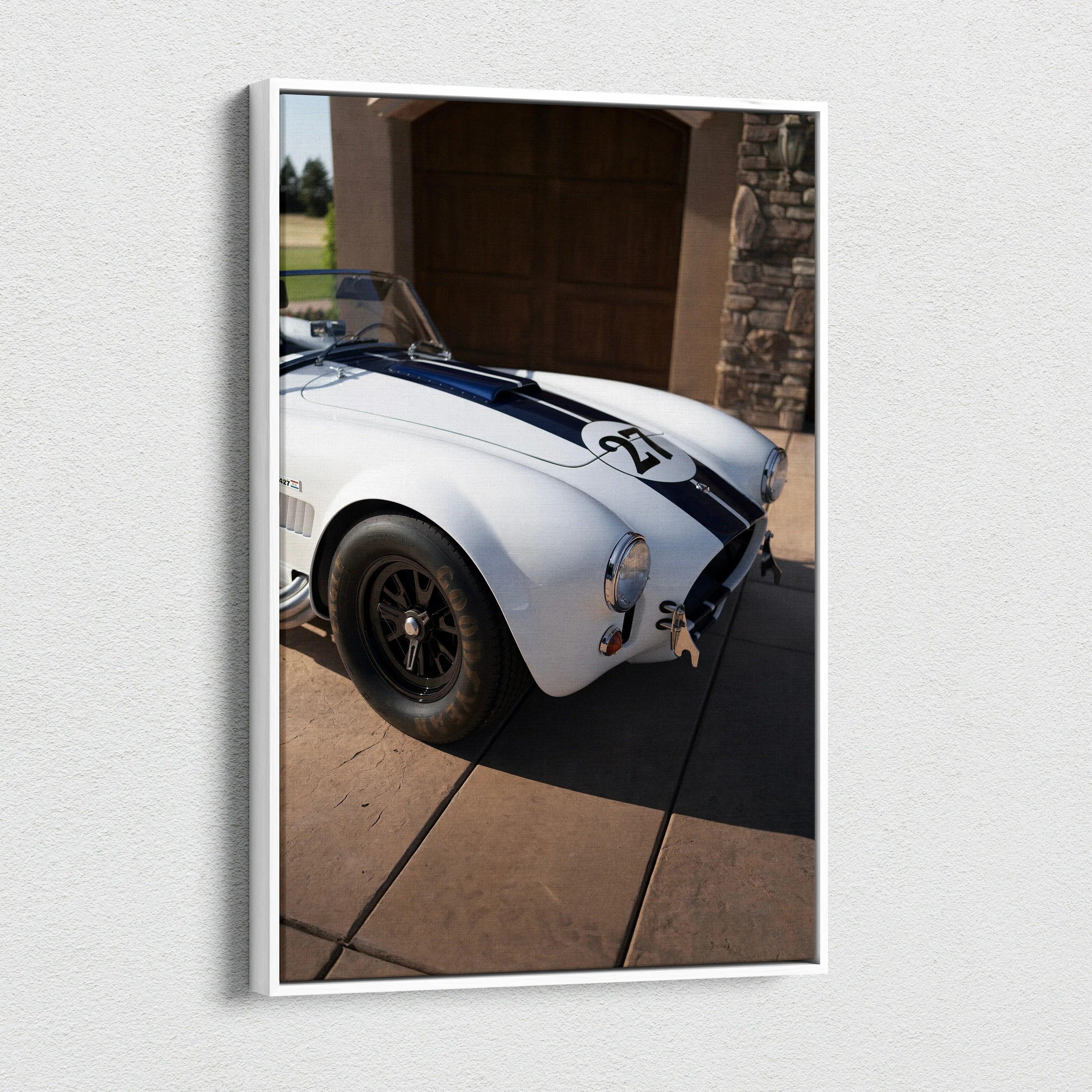Vertical canvas art featuring a white Shelby Cobra with black racing stripes in a driveway setting.
