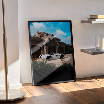 Shelby Cobra sports car wall art poster with bright blue sky and house background in black frame.