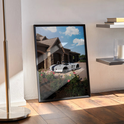 Shelby Cobra car poster leaning against wall with house and blue sky, modern wall art.