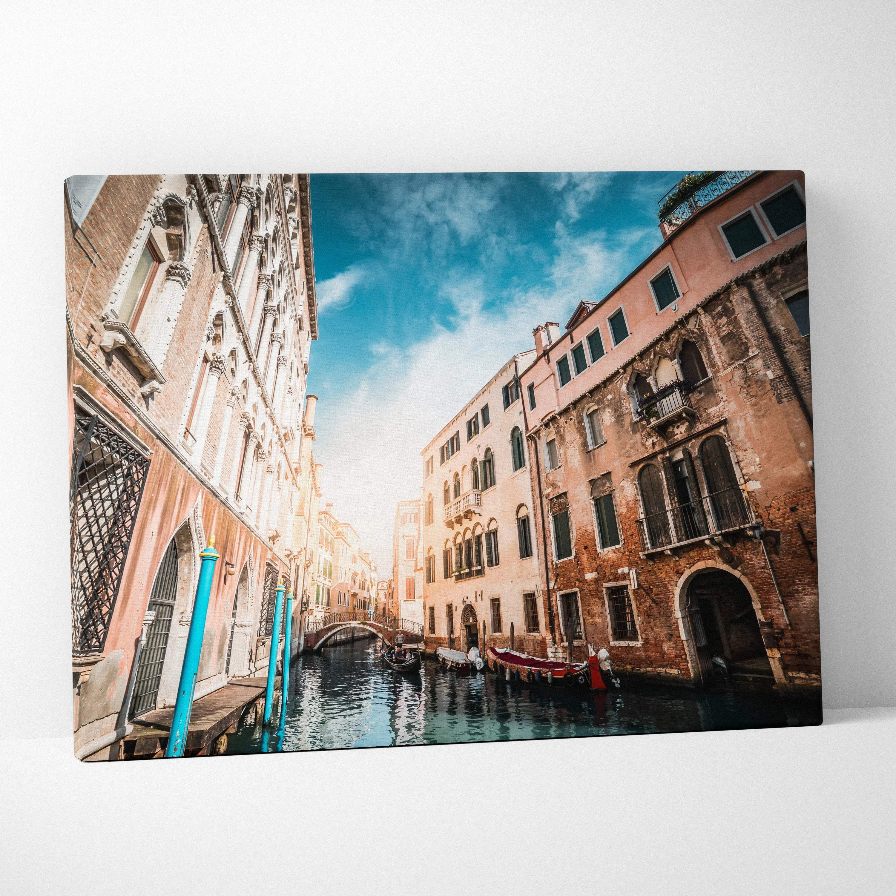 High-resolution canvas wall art featuring an urban canal scene with historic buildings and gondolas under a vibrant sky.