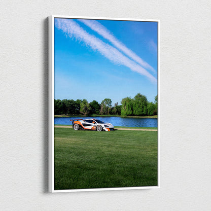 Vertical canvas wall art featuring a McLaren 570S on green grass by a lake under a blue sky.