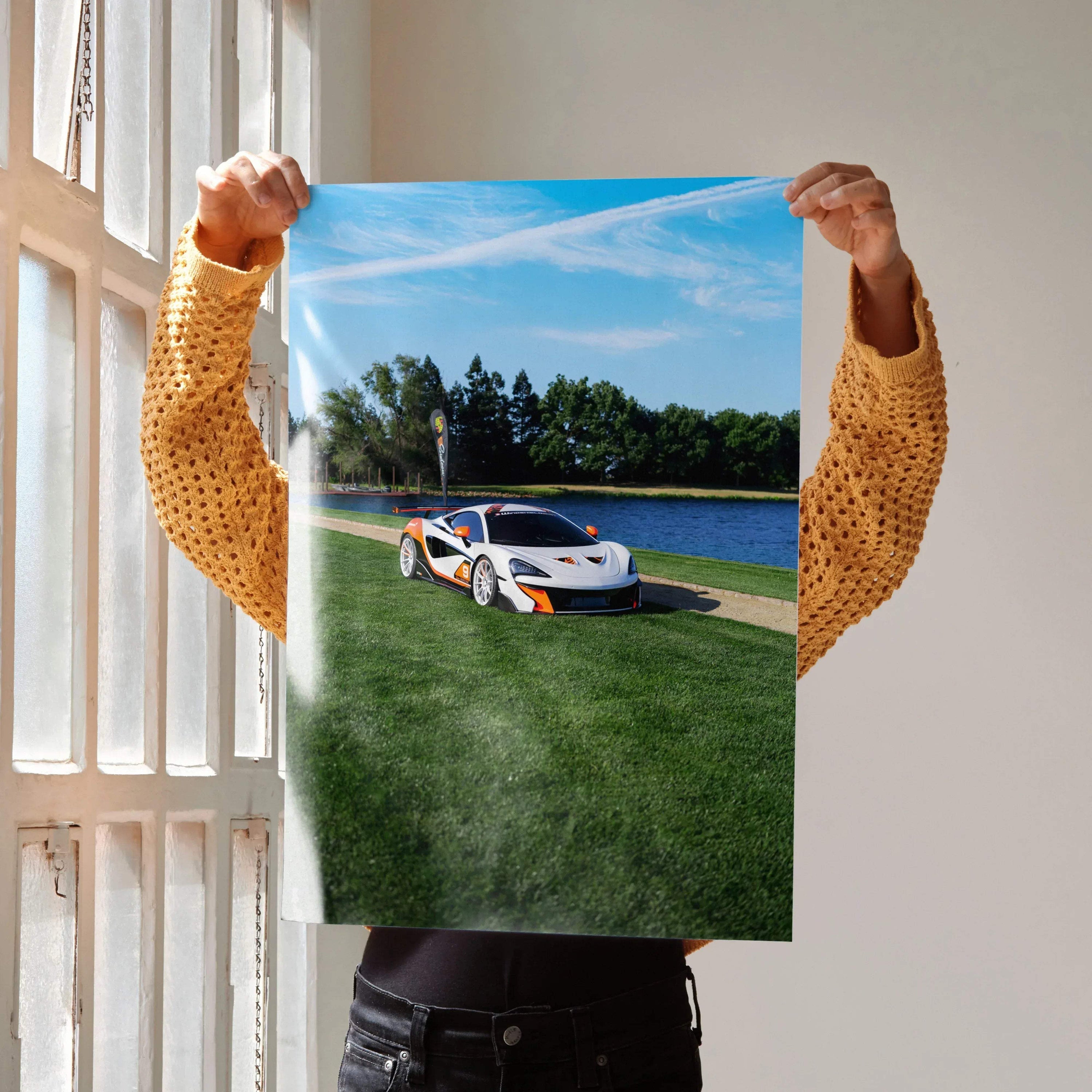 McLaren 570S poster showing white sports car on green grass near water under blue sky, wall art.