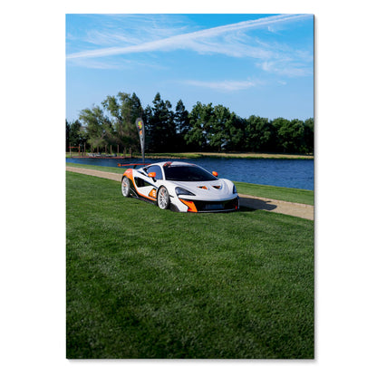McLaren 570S sports car on green grass near water under blue sky poster wall art.