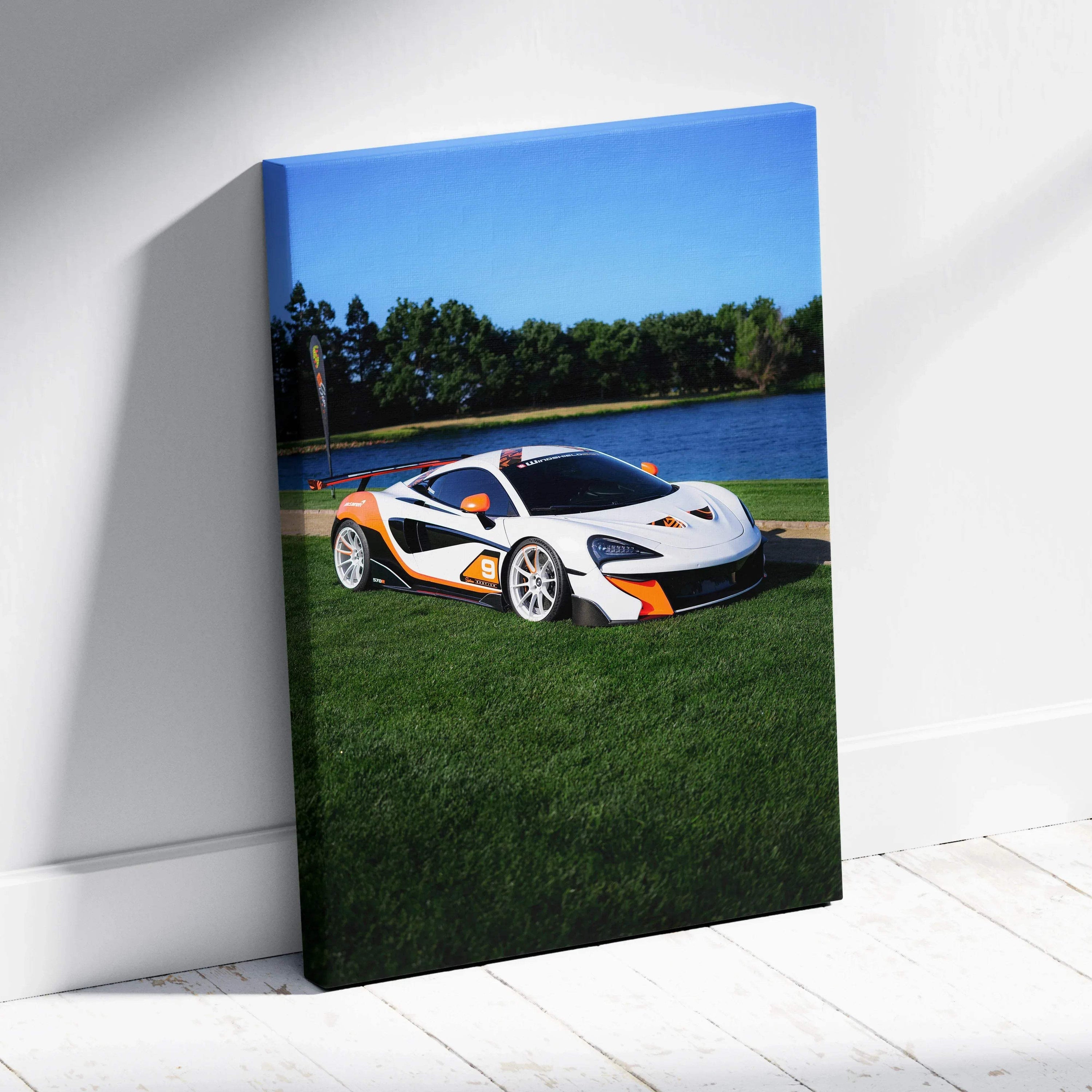 Vertical canvas wall art featuring a white McLaren 570S with orange accents on green grass by a lake.