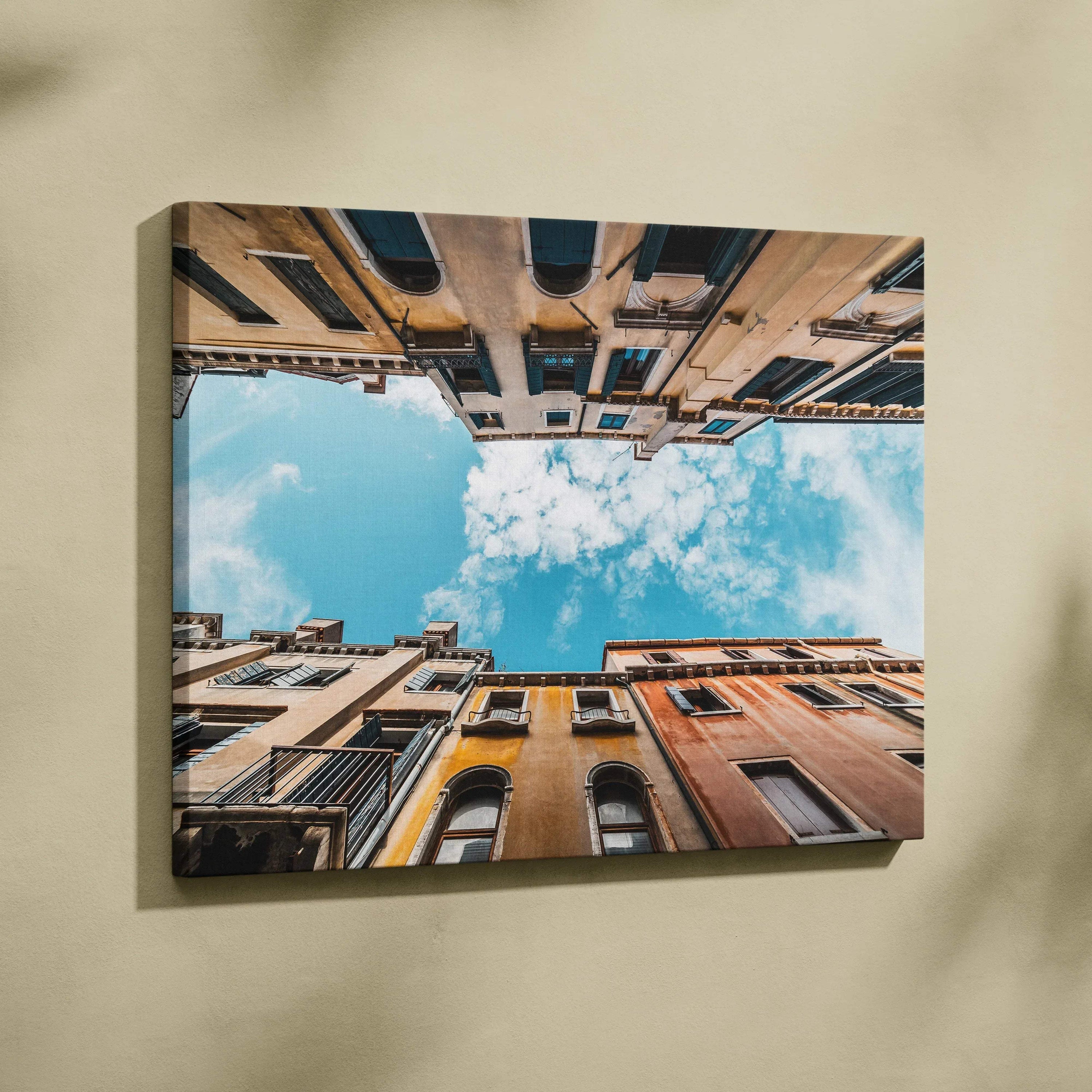 Urban architecture canvas wall art showing upward view of buildings and blue sky with clouds.