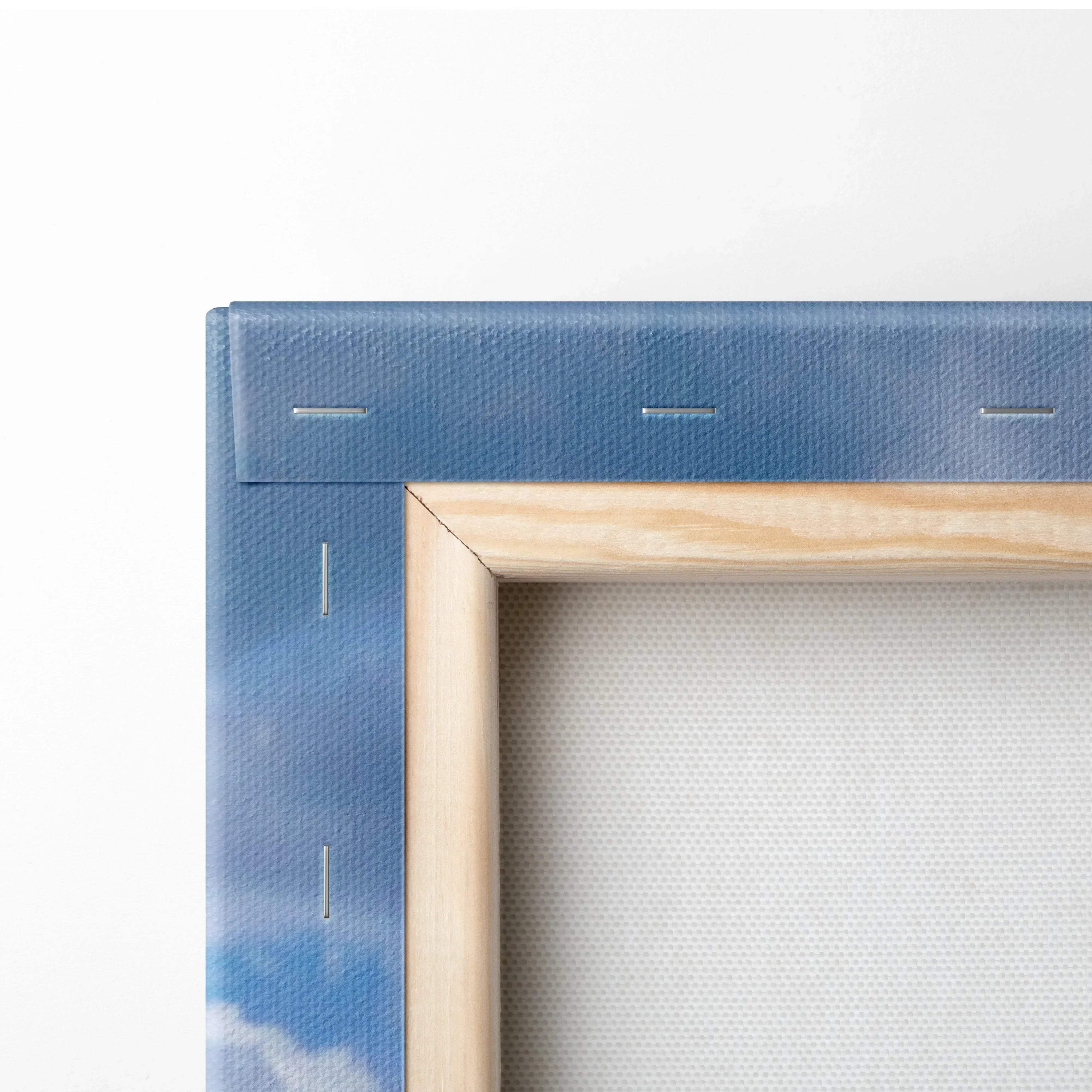 Close-up of wooden frame and blue sky background on vertical canvas wall art with visible staples and textured fabric backing.