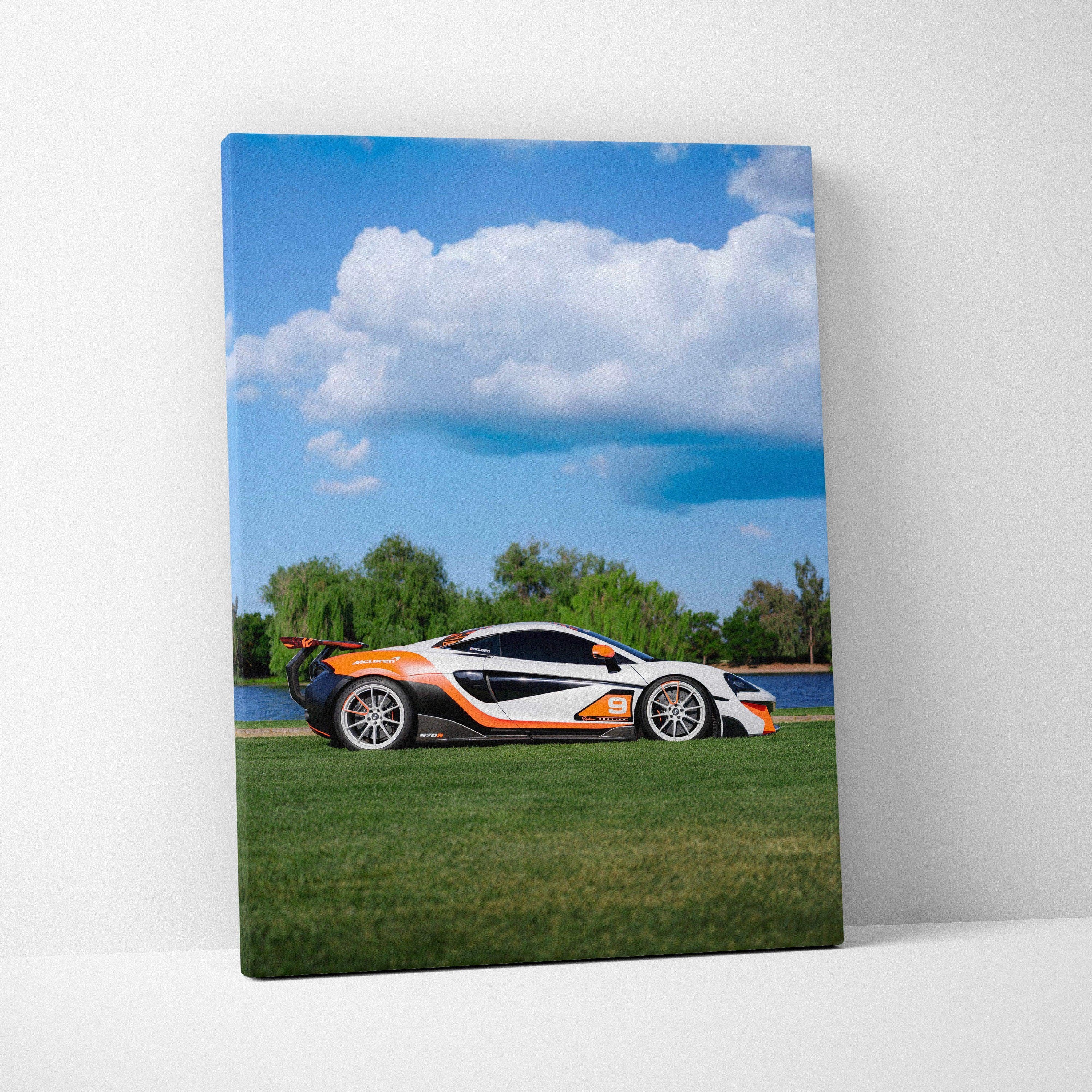 McLaren 570S sports car on grass with blue sky and clouds vertical canvas wall art.