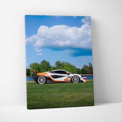 McLaren 570S sports car on grass with blue sky and clouds vertical canvas wall art.