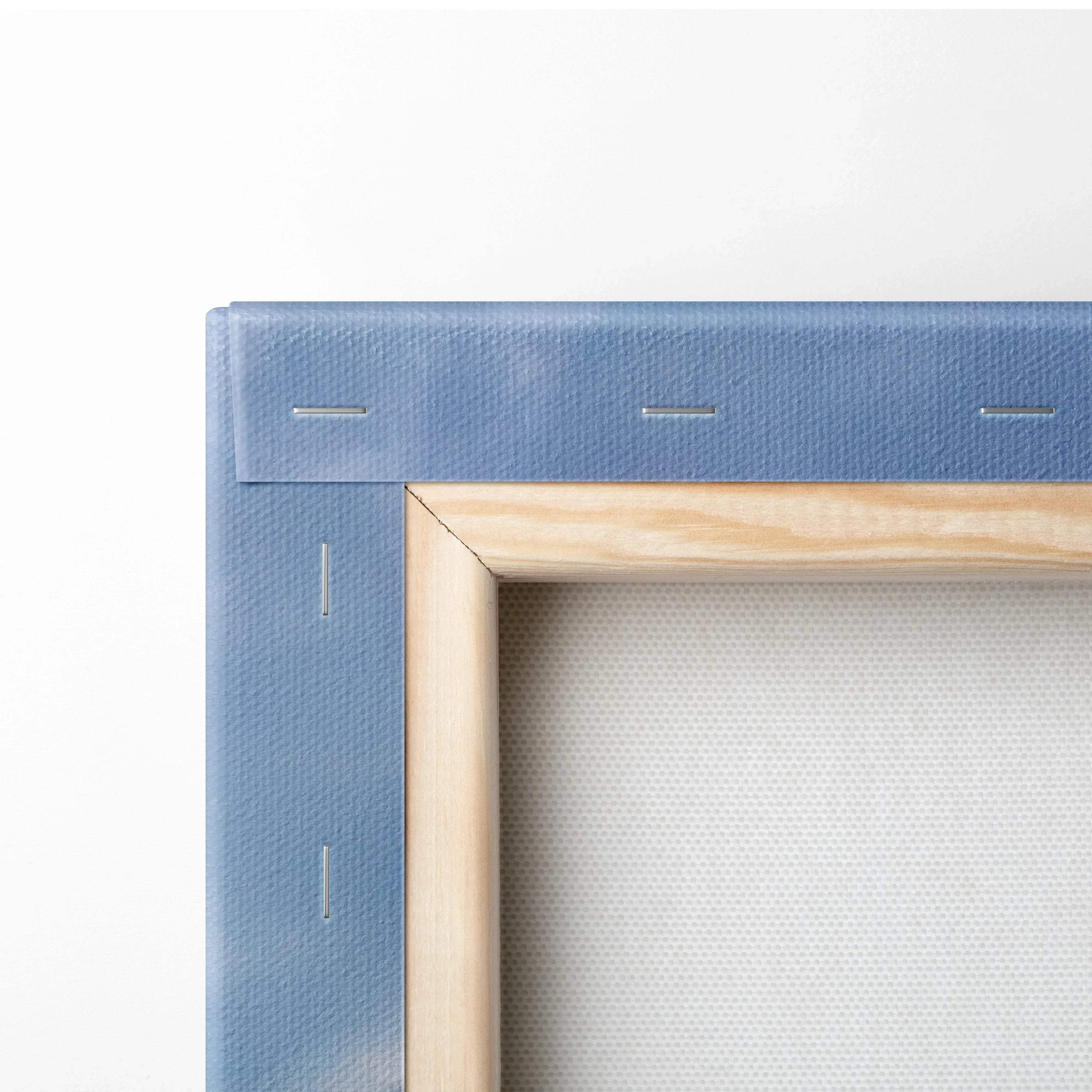 Close-up of blue stretched canvas with wooden stretcher bars and metal staples for wall art canvas print.