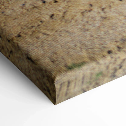 Close-up of textured beige canvas wall art corner with subtle speckled pattern and sharp edges.