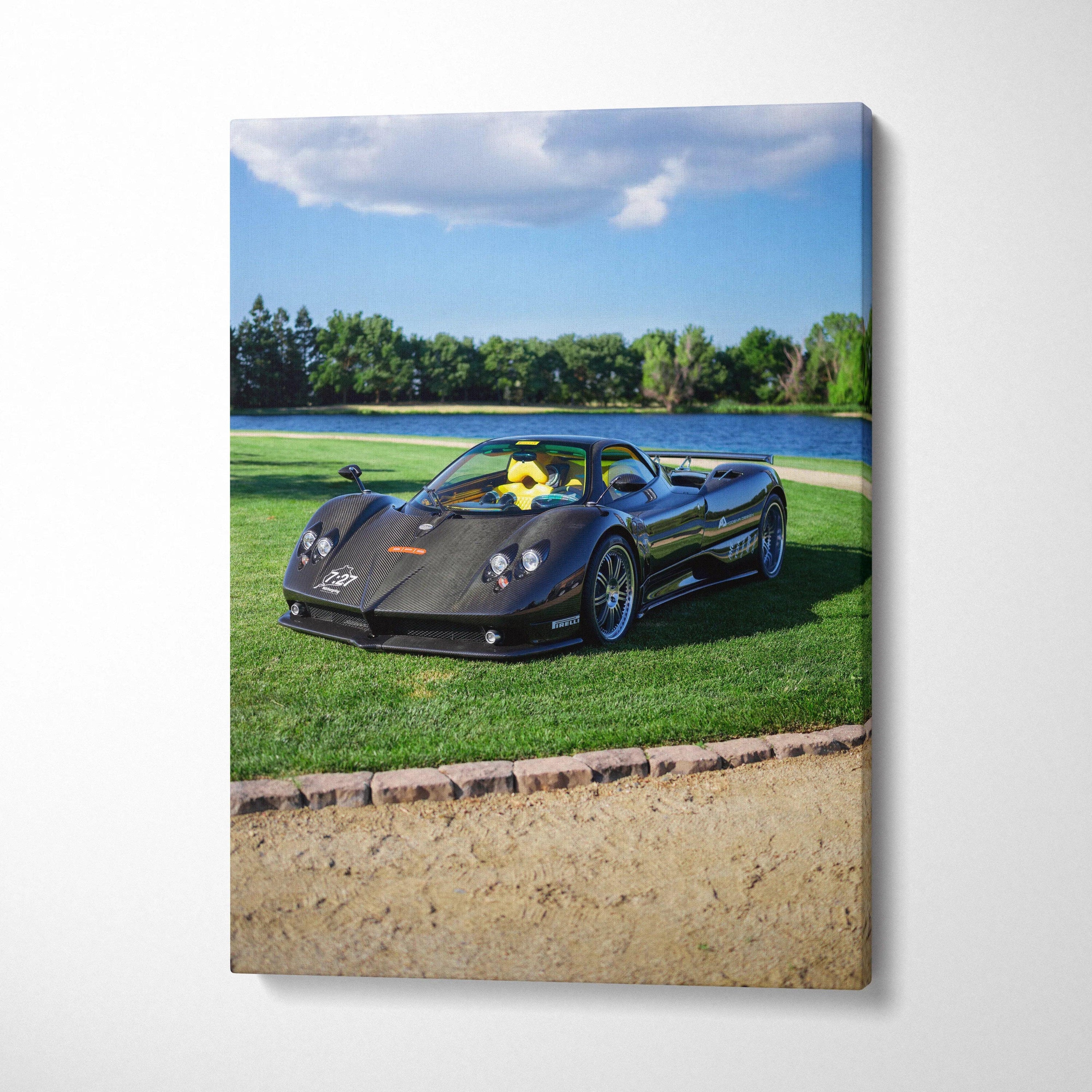 Vertical canvas wall art featuring a black Pagani Zonda F Clubsport on grass by a lake under blue sky.