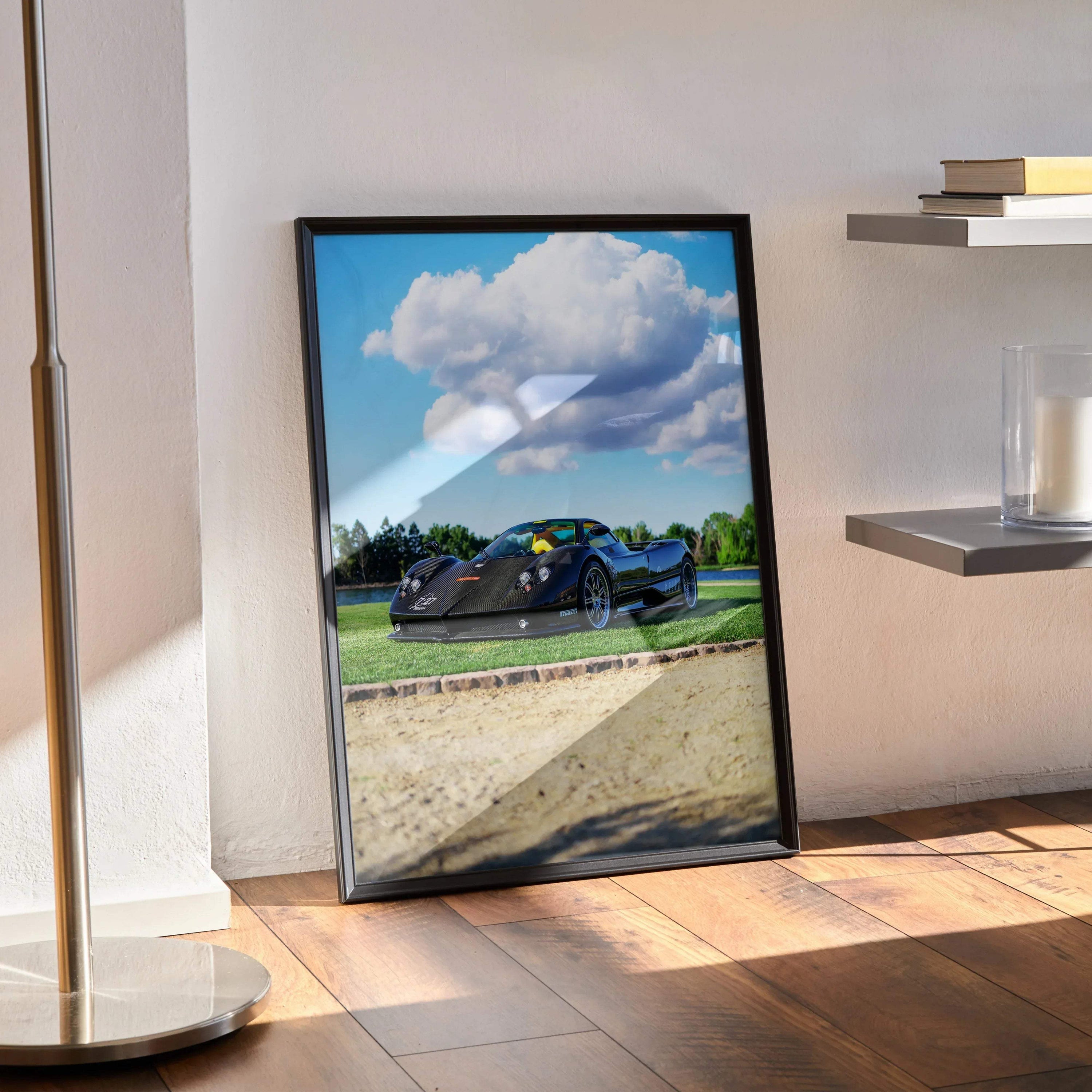 Pagani Zonda F Clubsport car poster with blue sky and green landscape in black frame leaning on wooden floor wall art.