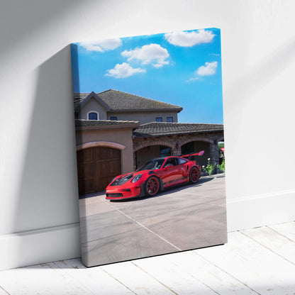 Red Porsche 911 GT3 RS parked in front of luxury home on vibrant canvas wall art.