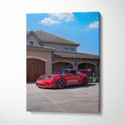 Red Porsche 911 GT3 RS parked outside luxury home, vibrant blue sky canvas wall art.