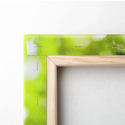 Close-up of wooden framed canvas wall art with vibrant green and white abstract design.