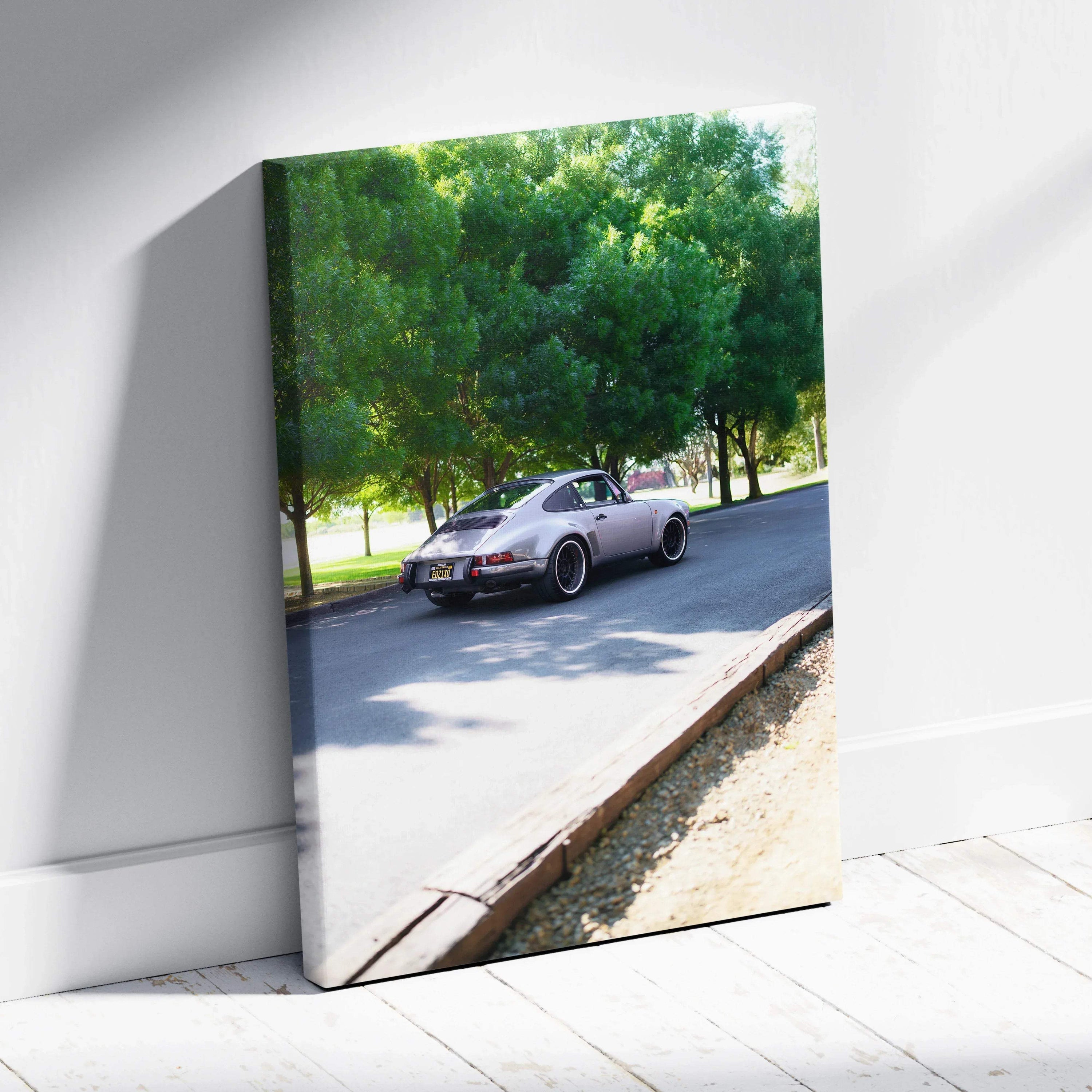 Porsche 911 classic car driving on sunny road canvas wall art with trees background.
