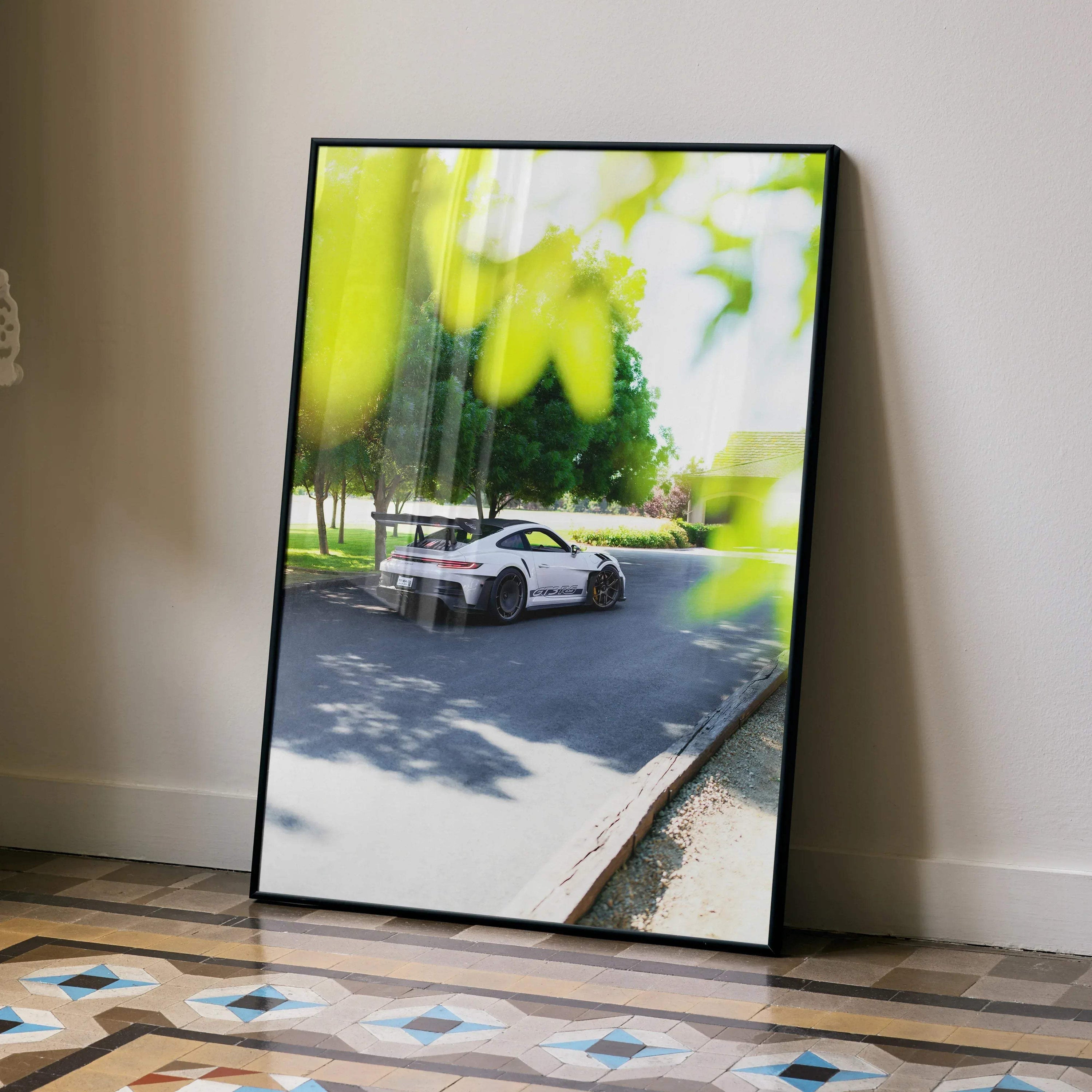 Porsche 911 GT3 RS driving on scenic road poster wall art in sleek black frame.
