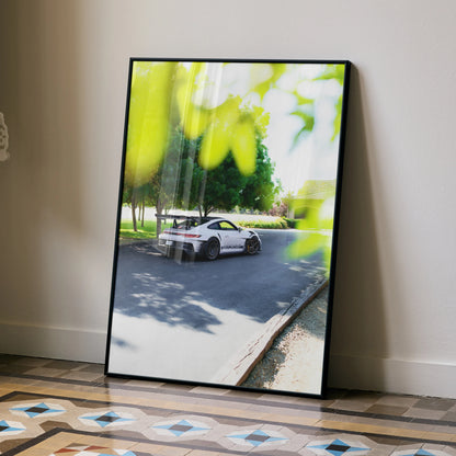 Porsche 911 GT3 RS driving on scenic road poster wall art in sleek black frame.