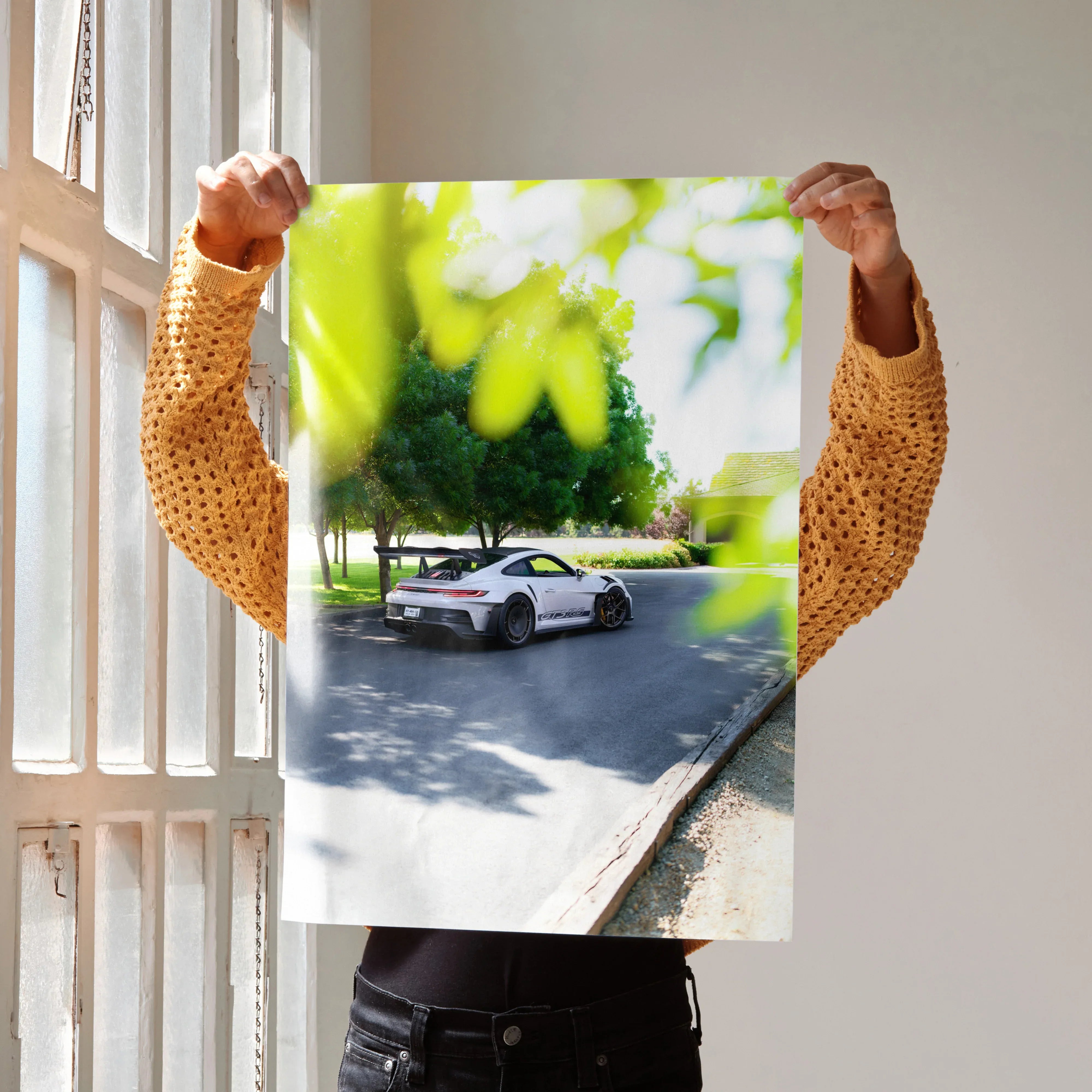 Porsche 911 GT3 RS parked on a tree-lined road poster wall art with vibrant green foliage.