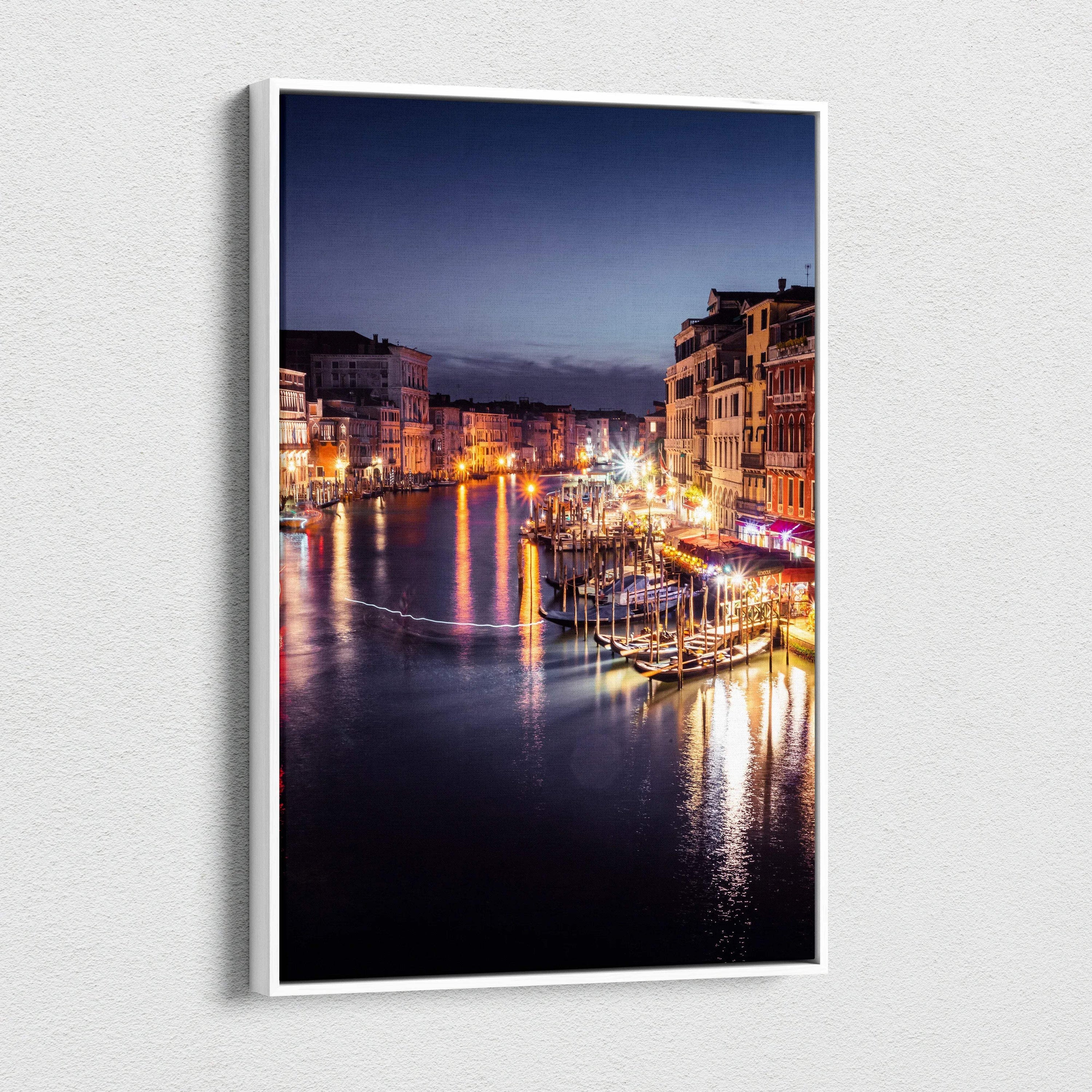Canvas wall art featuring a digitally enhanced nighttime urban landscape with illuminated buildings reflecting on water.