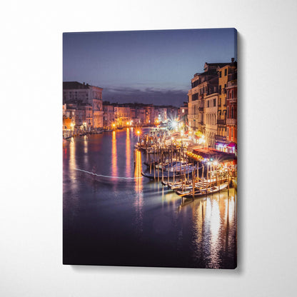 Canvas wall art featuring a luminous urban waterfront scene with buildings and glowing night reflections.