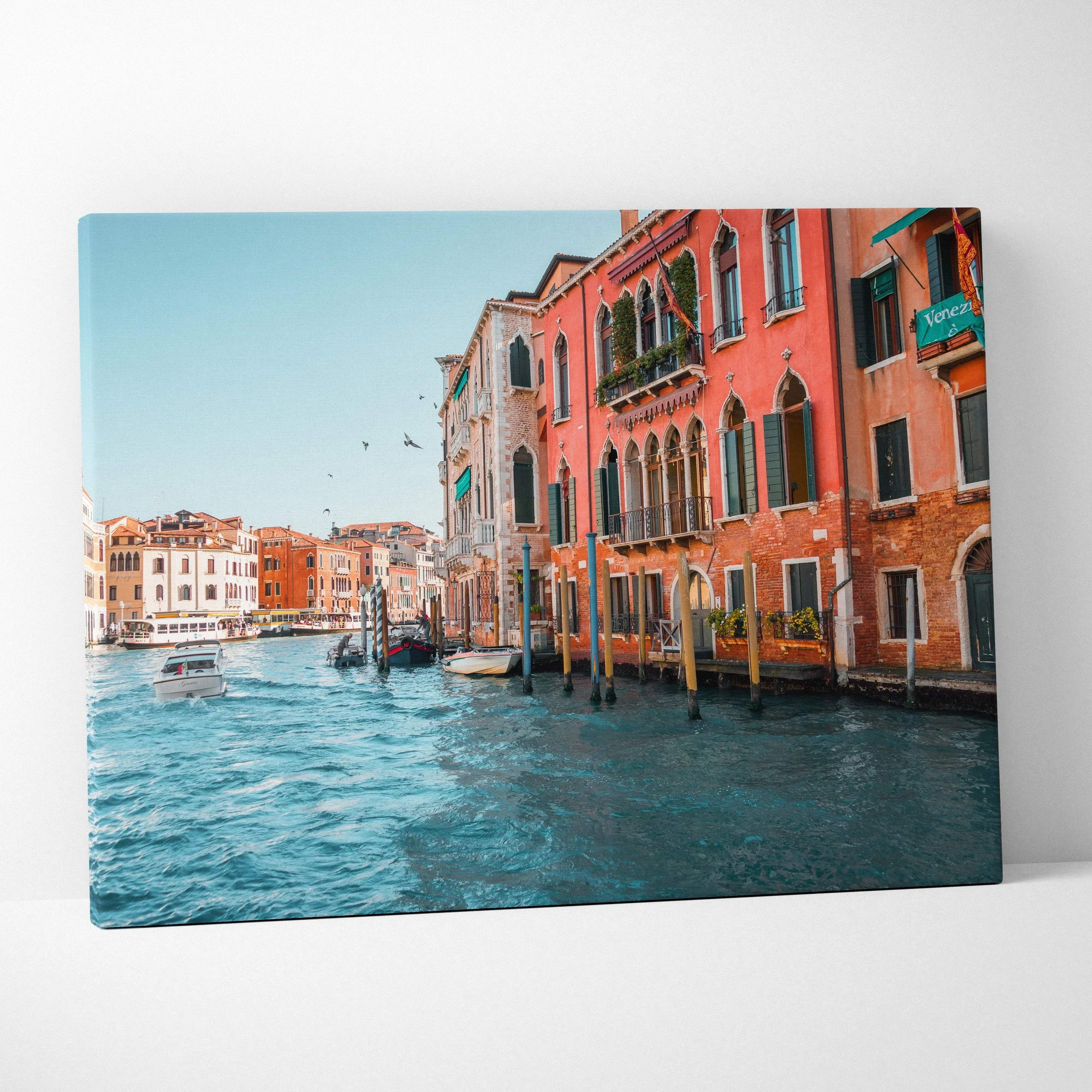 Canvas wall art featuring vibrant, detailed architecture of colorful buildings along a canal with boats and a bright blue.