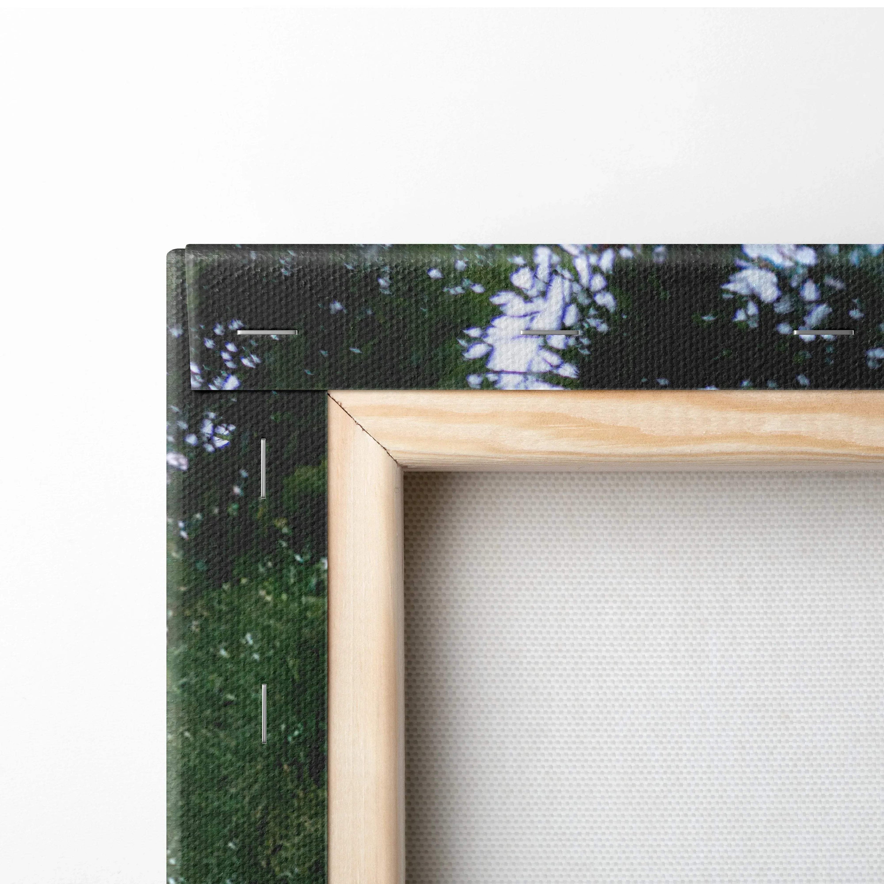 Close-up of natural wood frame corner on vertical canvas art with textured print surface.
