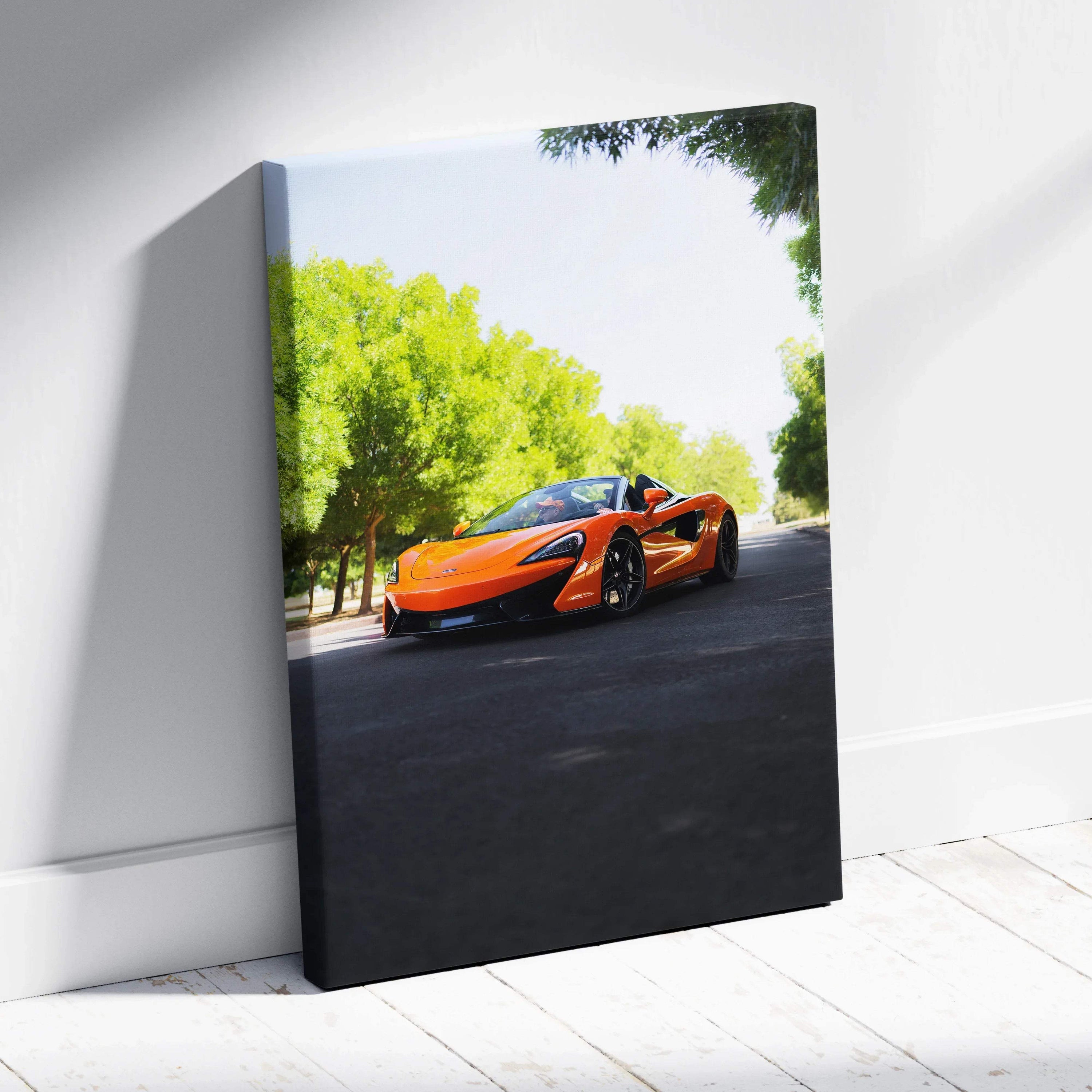 Orange McLaren 570S on black asphalt with green trees, vertical canvas wall art.
