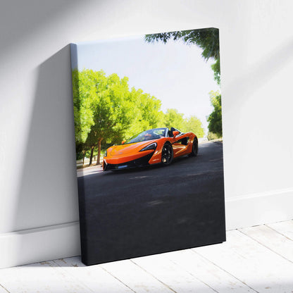 Orange McLaren 570S on black asphalt with green trees, vertical canvas wall art.
