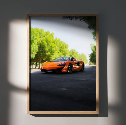 McLaren 570S orange sports car on road with green trees, framed poster wall art.