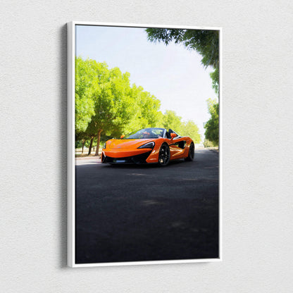 Vertical canvas wall art featuring an orange McLaren 570S sports car on a sunlit road with green trees.