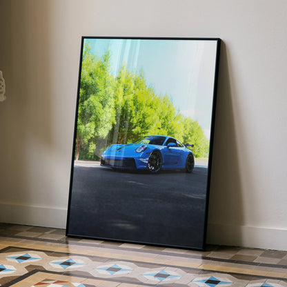 Blue Porsche 911 GT3 parked with green trees in background, modern wall art poster with black frame.