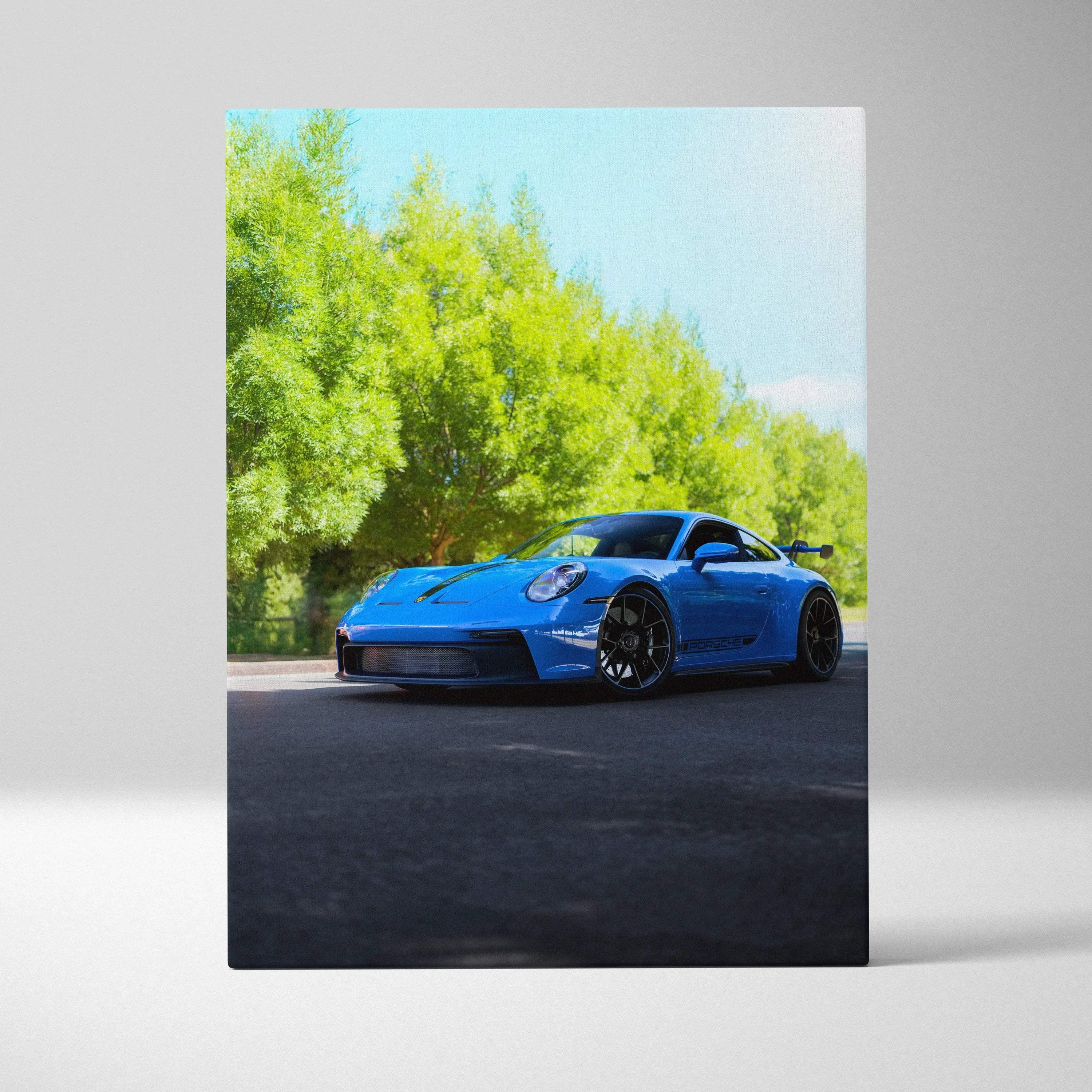 Blue Porsche 911 GT3 parked on blacktop under green trees canvas wall art vertical print.