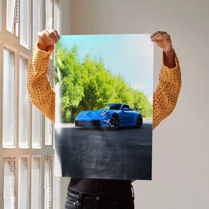 Porsche 911 GT3 in blue on road with green trees background poster wall art.