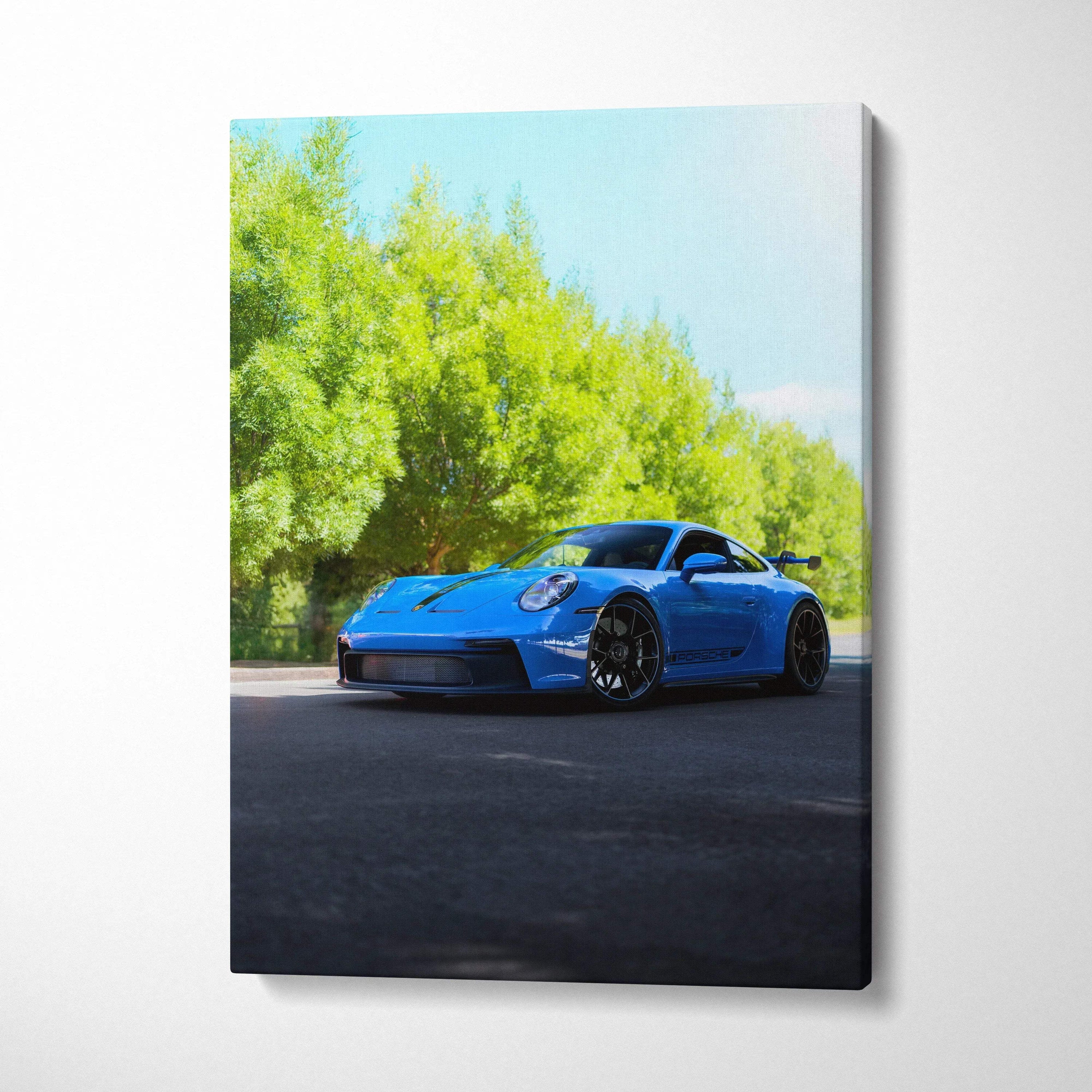 Blue Porsche 911 GT3 sports car on road with green trees canvas wall art.
