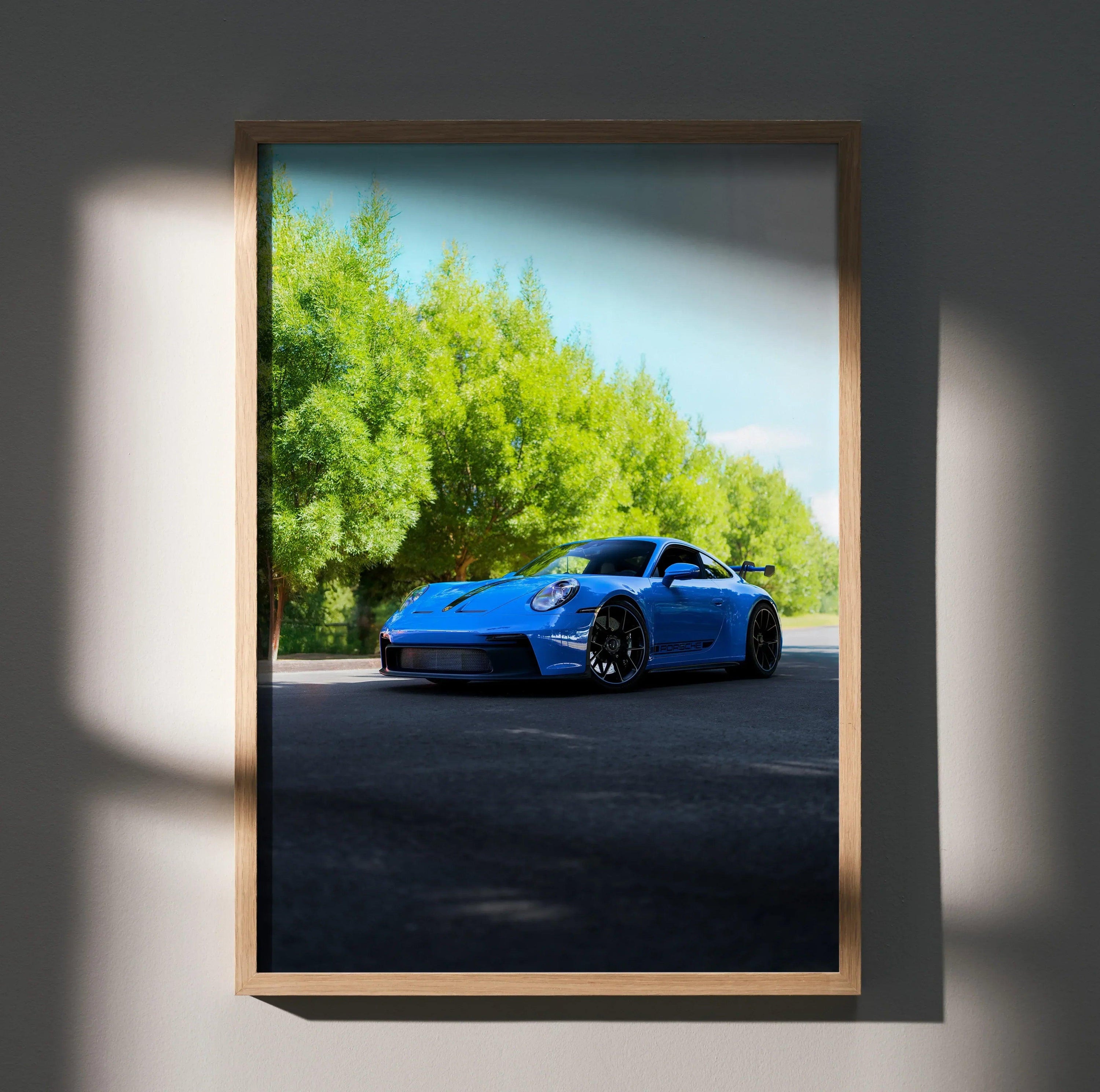 Blue Porsche 911 GT3 car on road with trees background framed as poster wall art.
