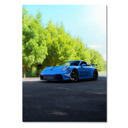 Blue Porsche 911 GT3 sports car on road with green trees backdrop poster wall art.