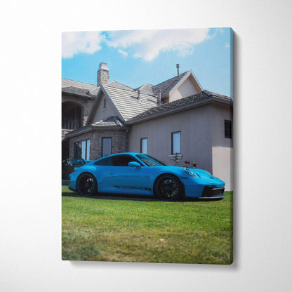 Porsche 911 GT3 in blue parked on grass in front of house canvas wall art vertical print.
