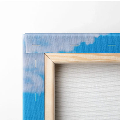 Close-up of a wooden frame edge with blue sky and clouds canvas wall art.