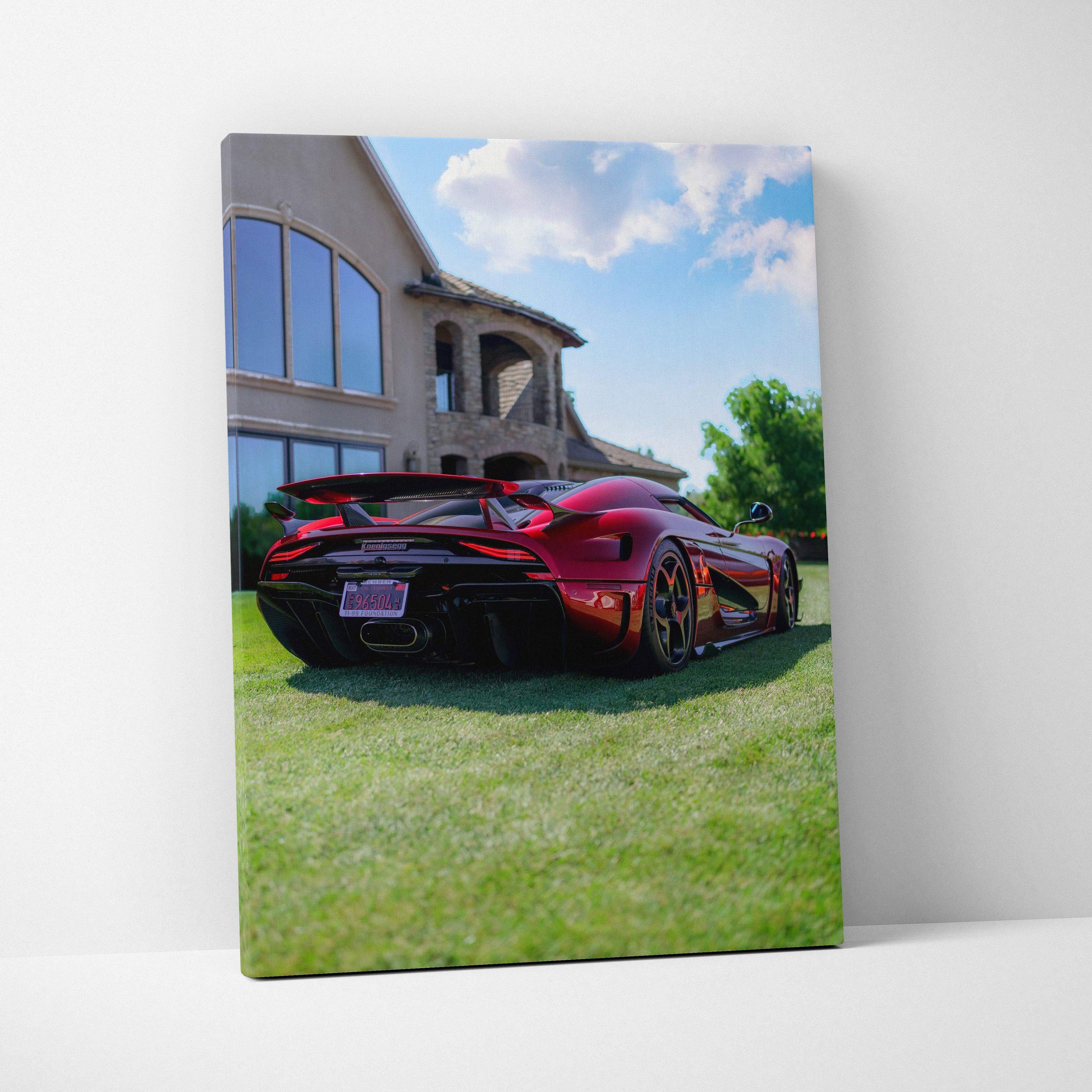 Vertical canvas art of a red Koenigsegg Regera parked on grass in front of a modern house under blue sky.