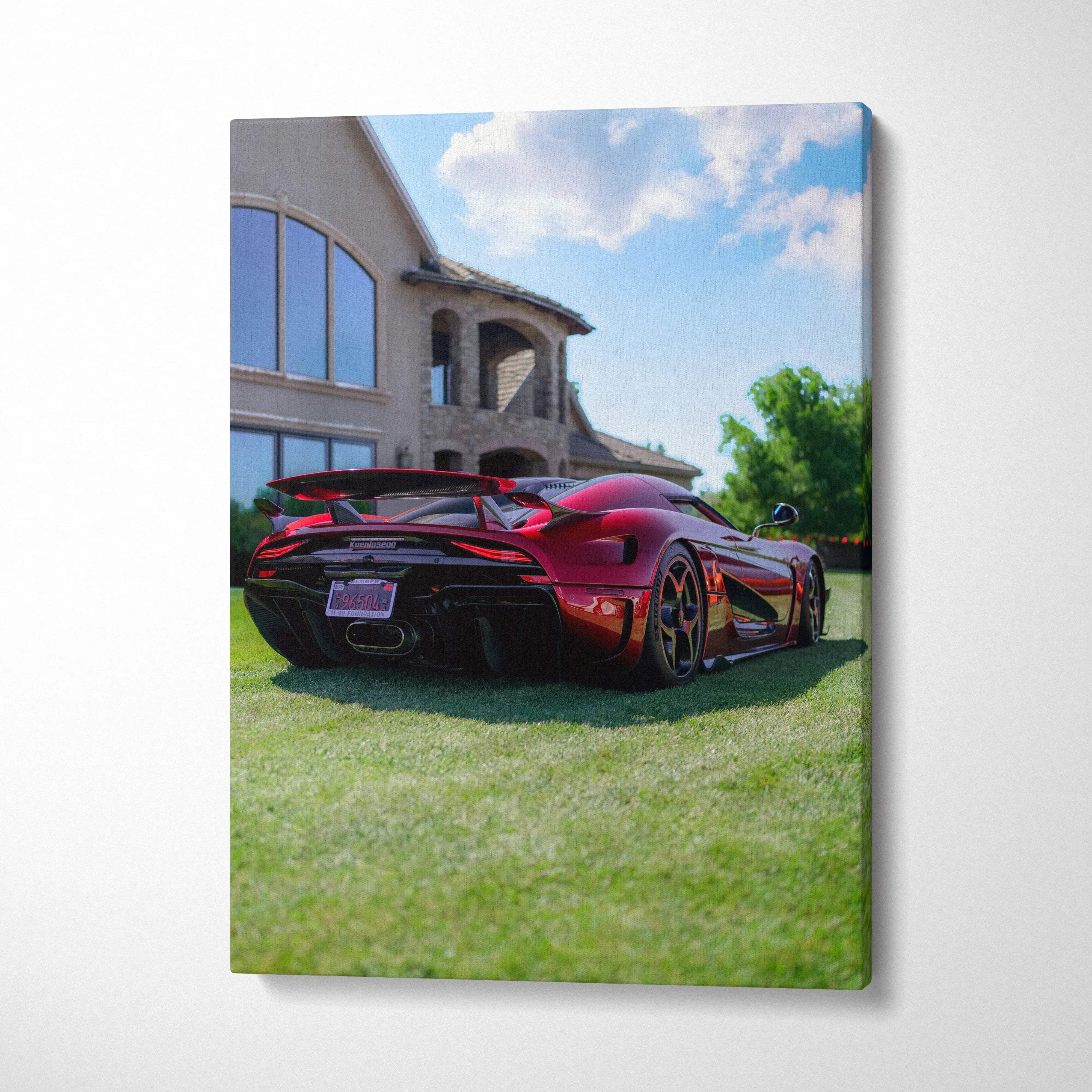 Red Koenigsegg Regera sports car on green lawn outside luxury home canvas wall art.