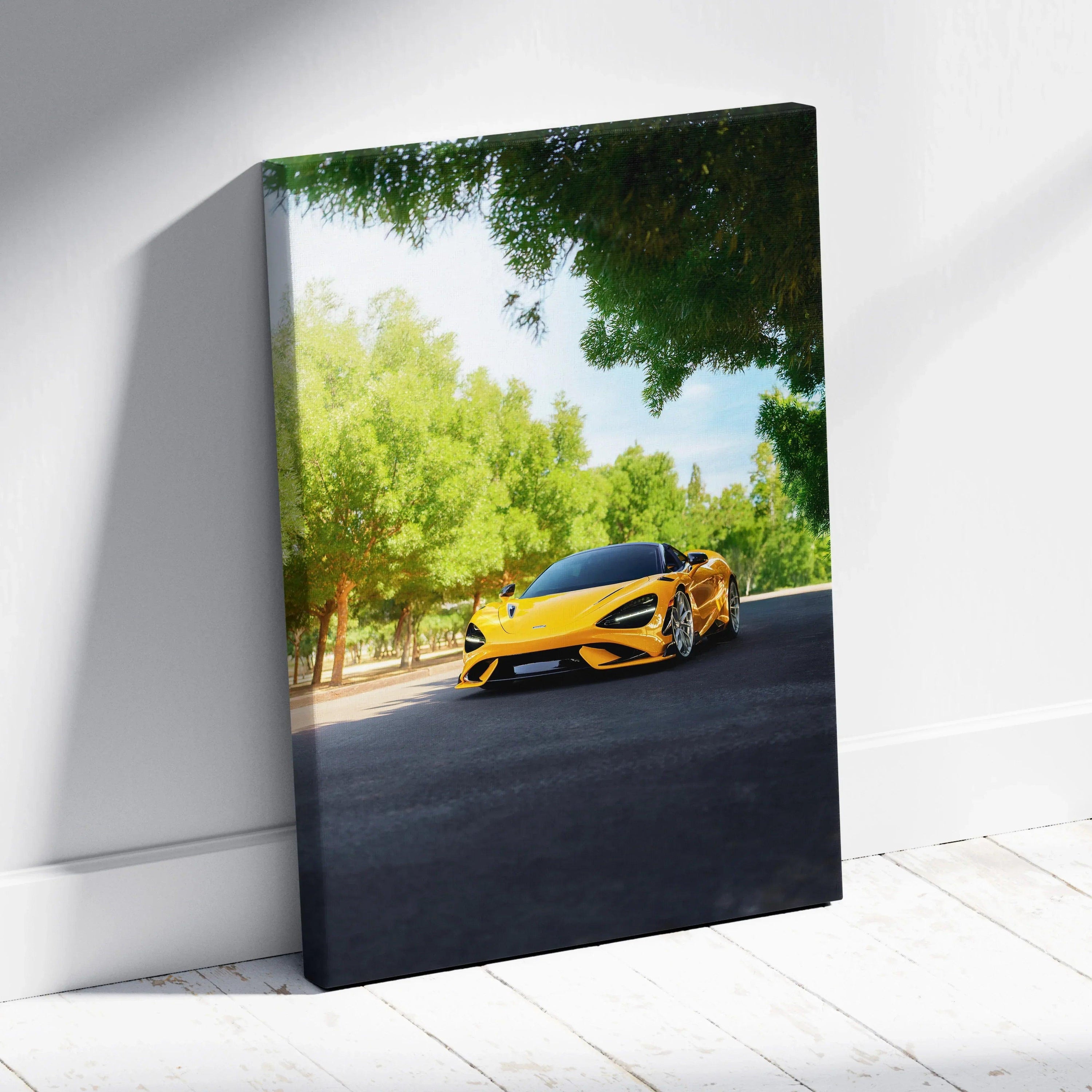 Vertical canvas wall art featuring a yellow McLaren 765LT on a shaded road with green trees.