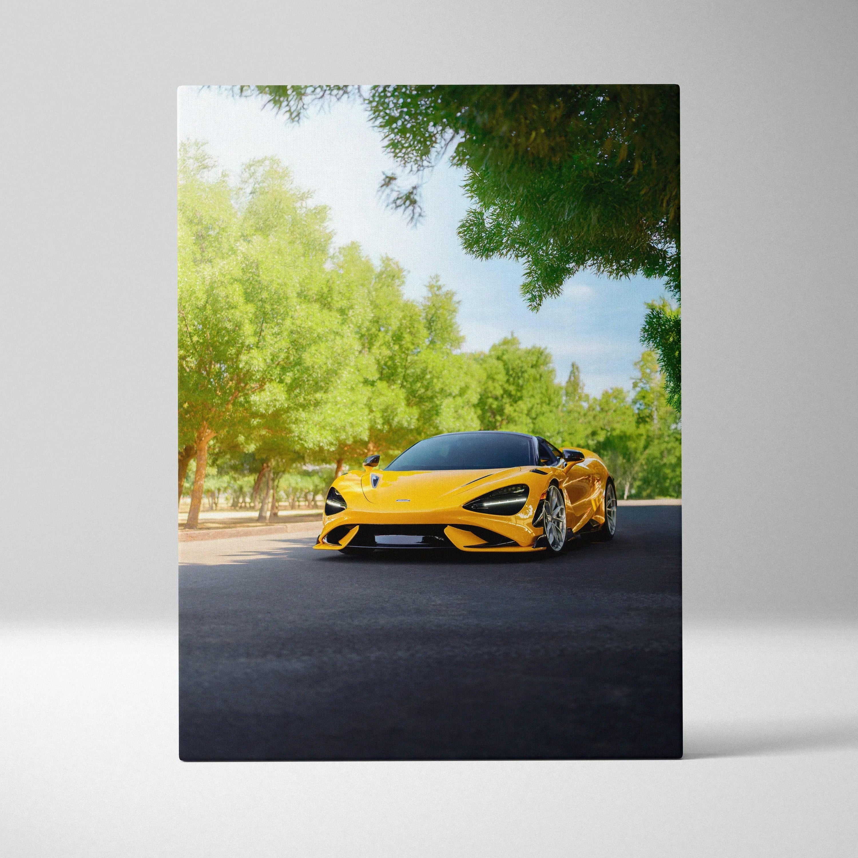Yellow McLaren 765LT sports car on road surrounded by green trees vertical canvas wall art.