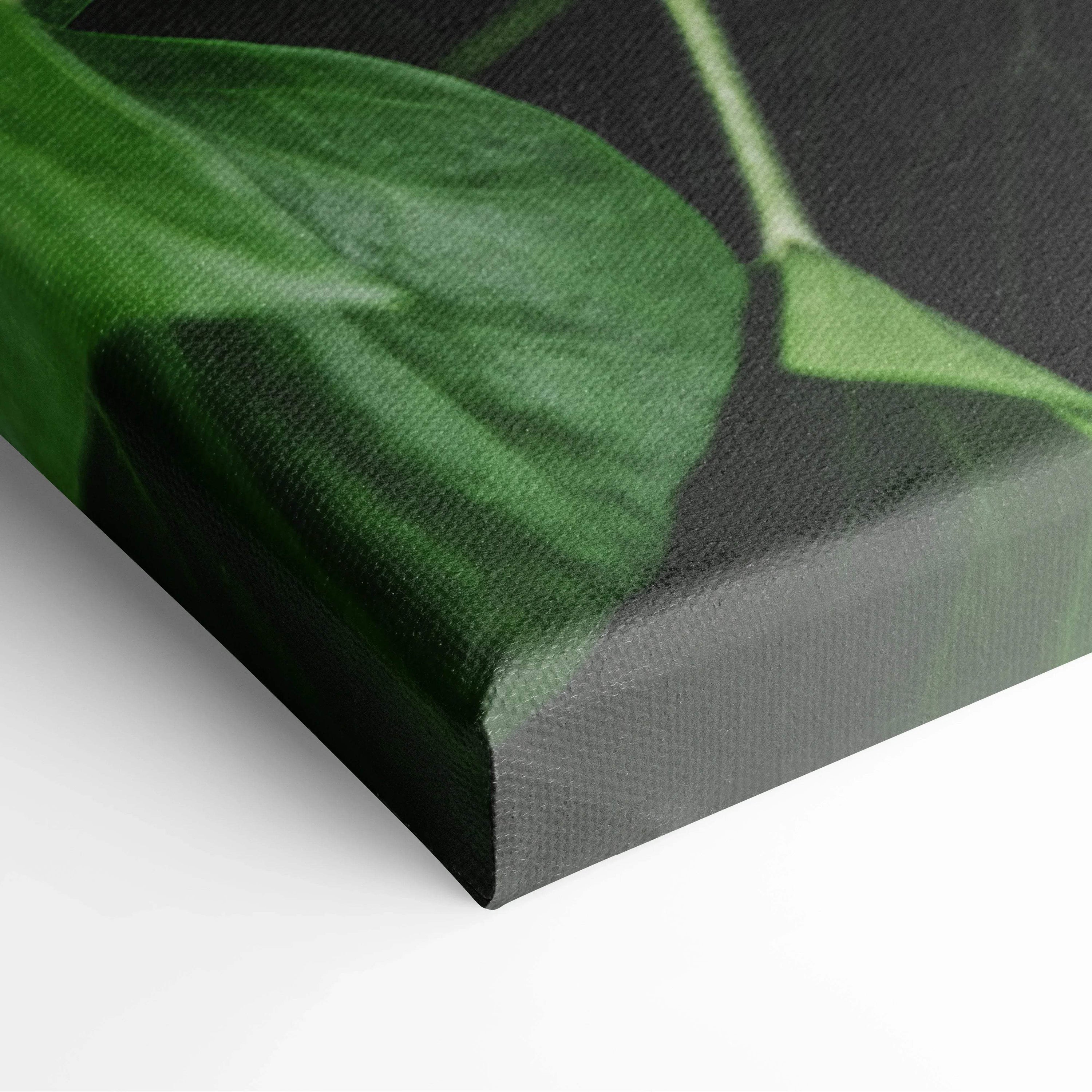 Close-up of green leaf detail on textured canvas wall art decor with lush botanical print.