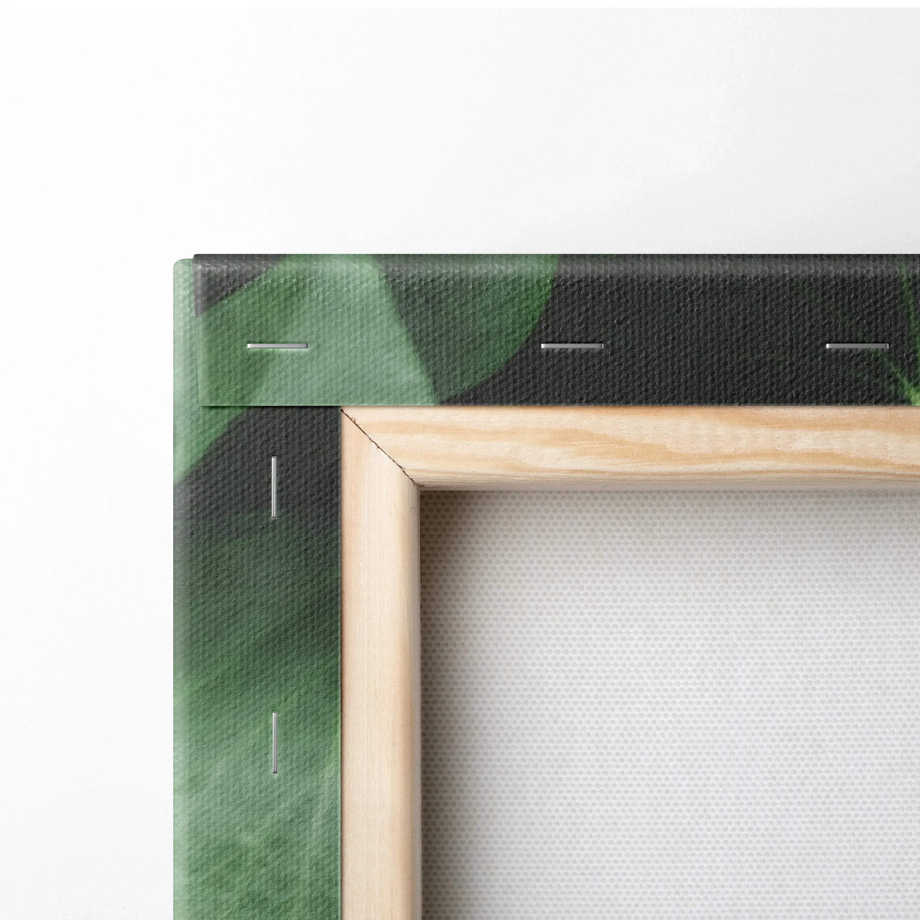 Close-up of stretched canvas corner with lush green leaf print and natural wood frame for wall art decor.