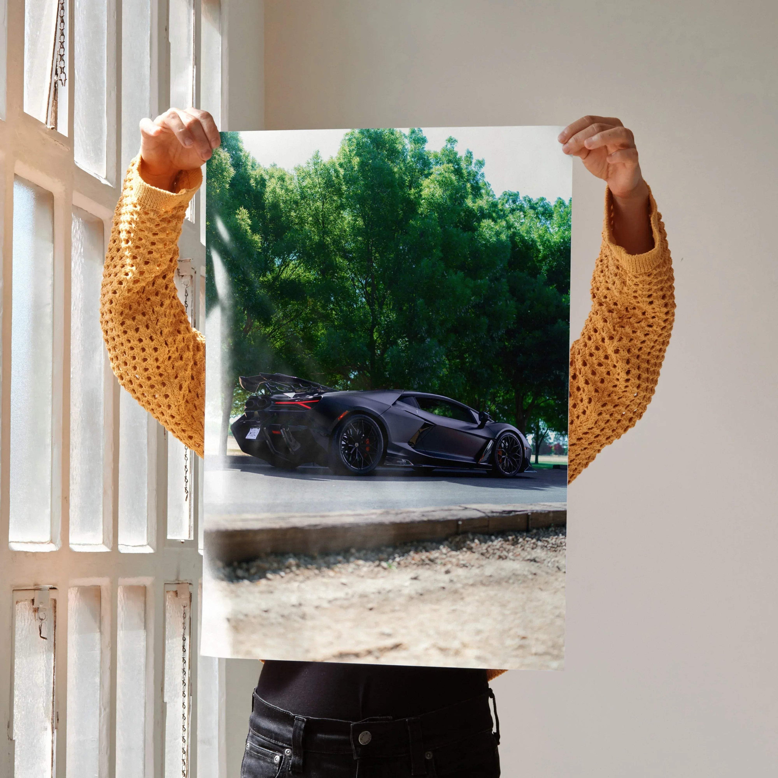 Lamborghini Revuelto poster showing sleek black sports car against green trees, perfect wall art.