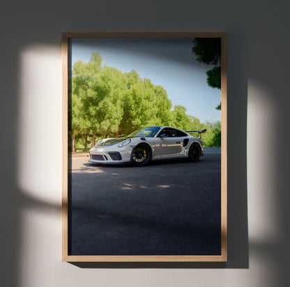 Porsche 911 GT3 sports car parked under trees with clear sky poster wall art in wooden frame.