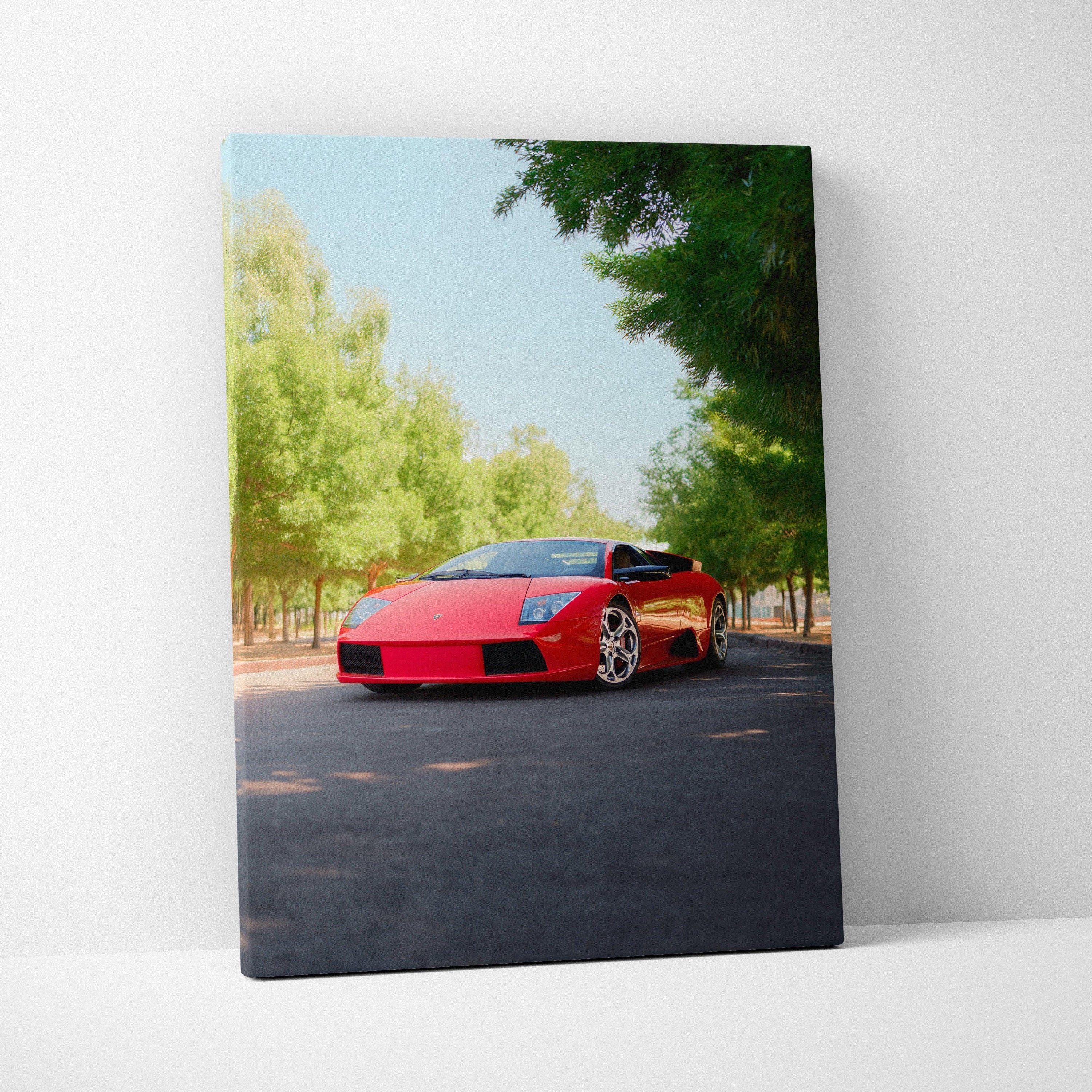 Red Lamborghini Murcielago on road surrounded by trees vertical canvas art wall decor.