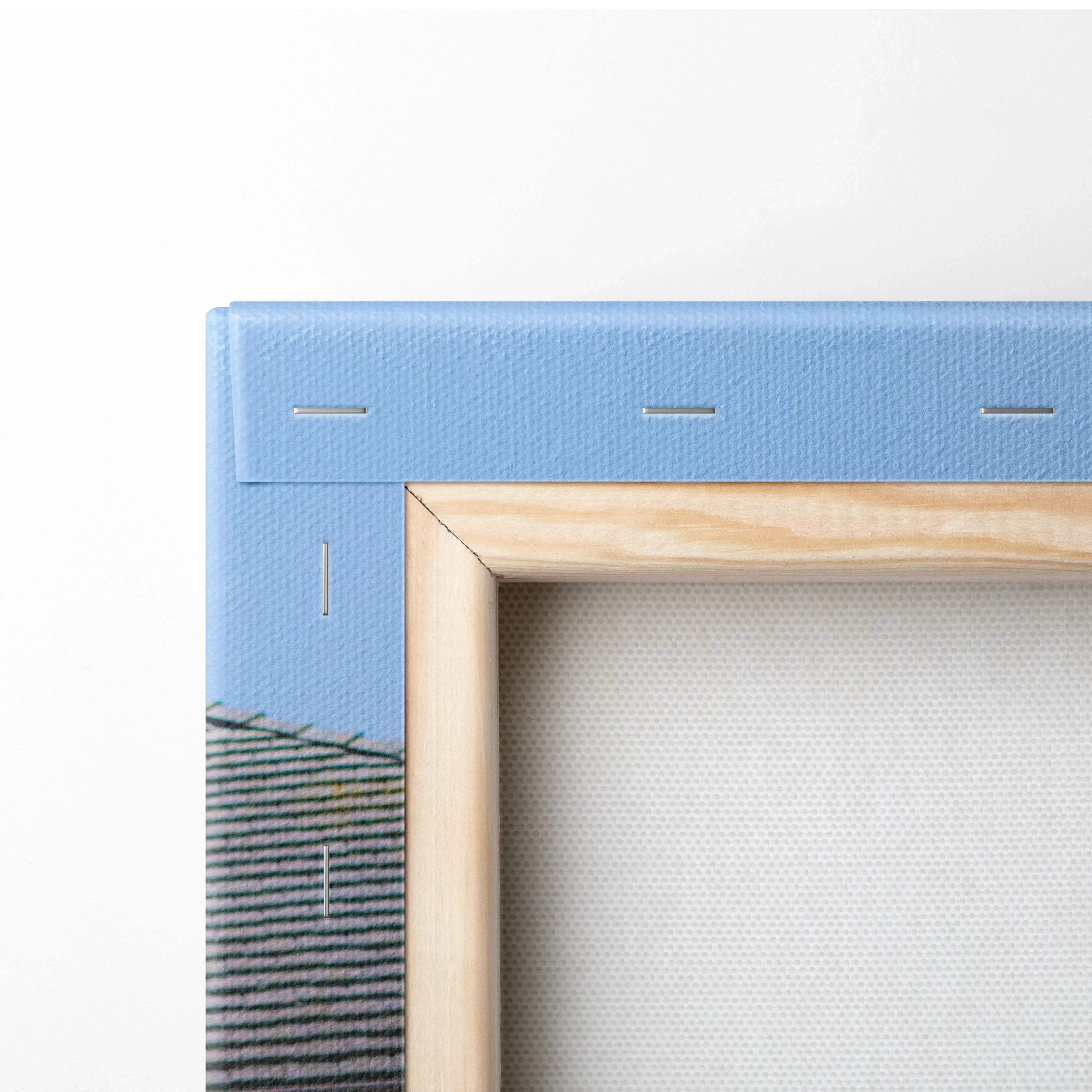 Close-up of wooden frame and blue canvas backing on vertical canvas wall art.
