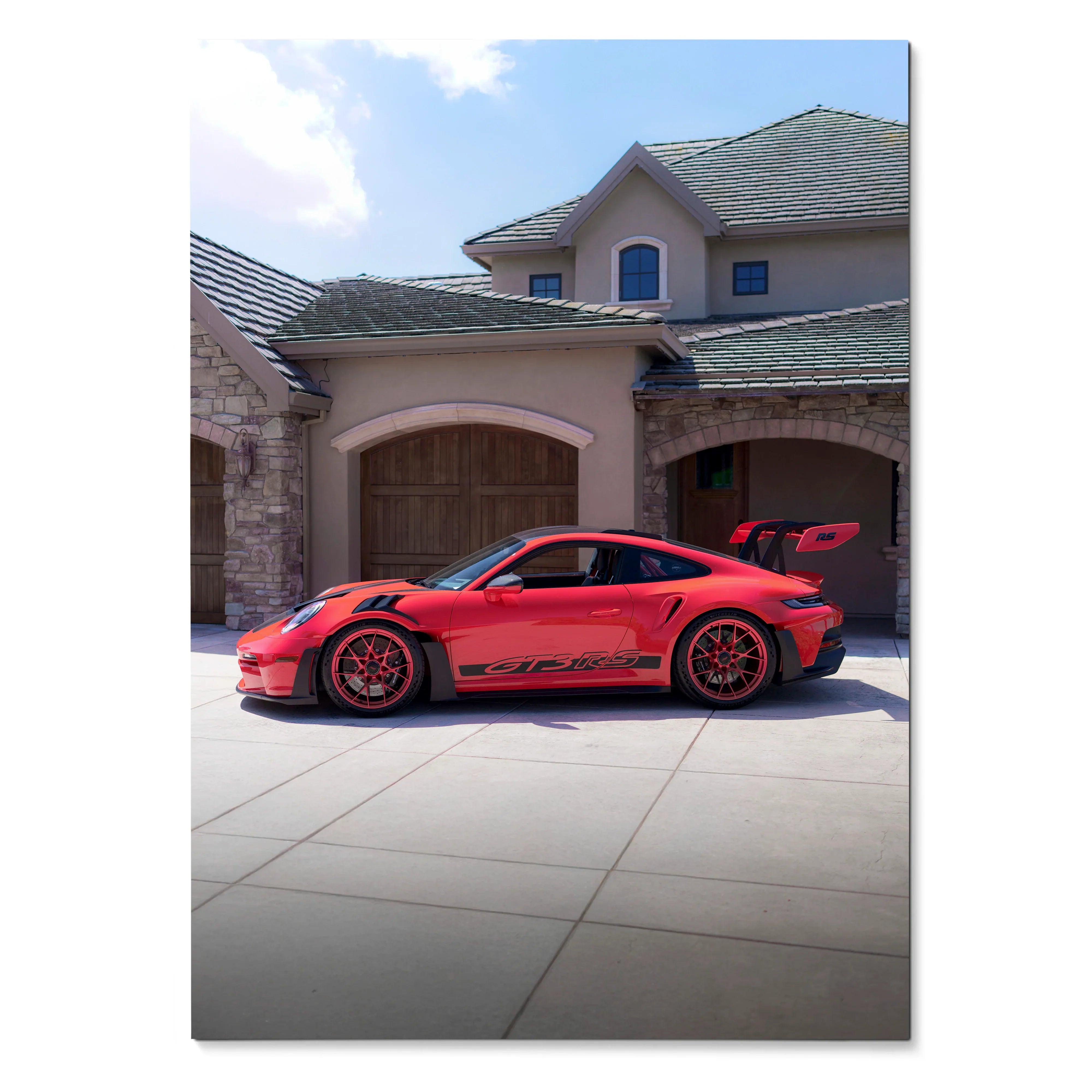 Red Porsche 911 GT3 RS with black decals parked in front of a beige house poster wall art.